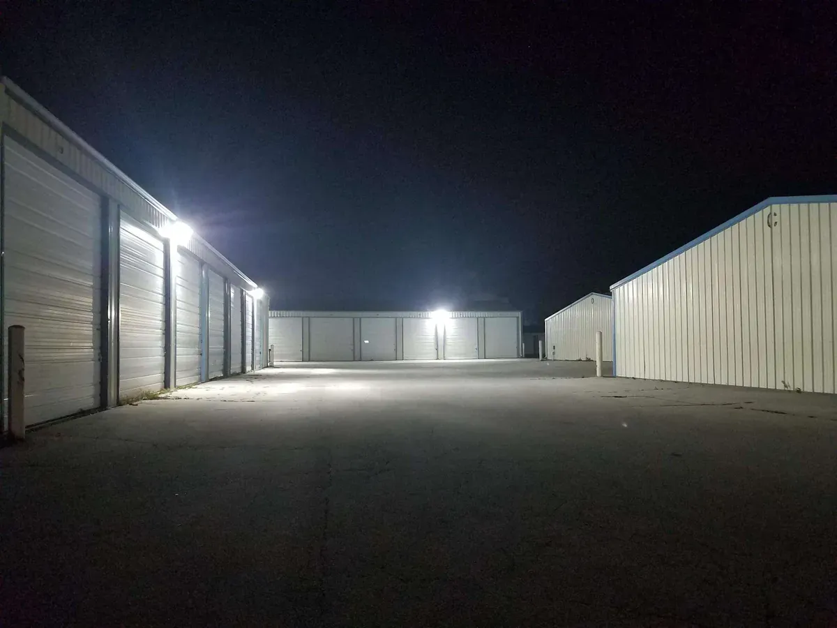 Multiple drive up self storage buildings well lit at night