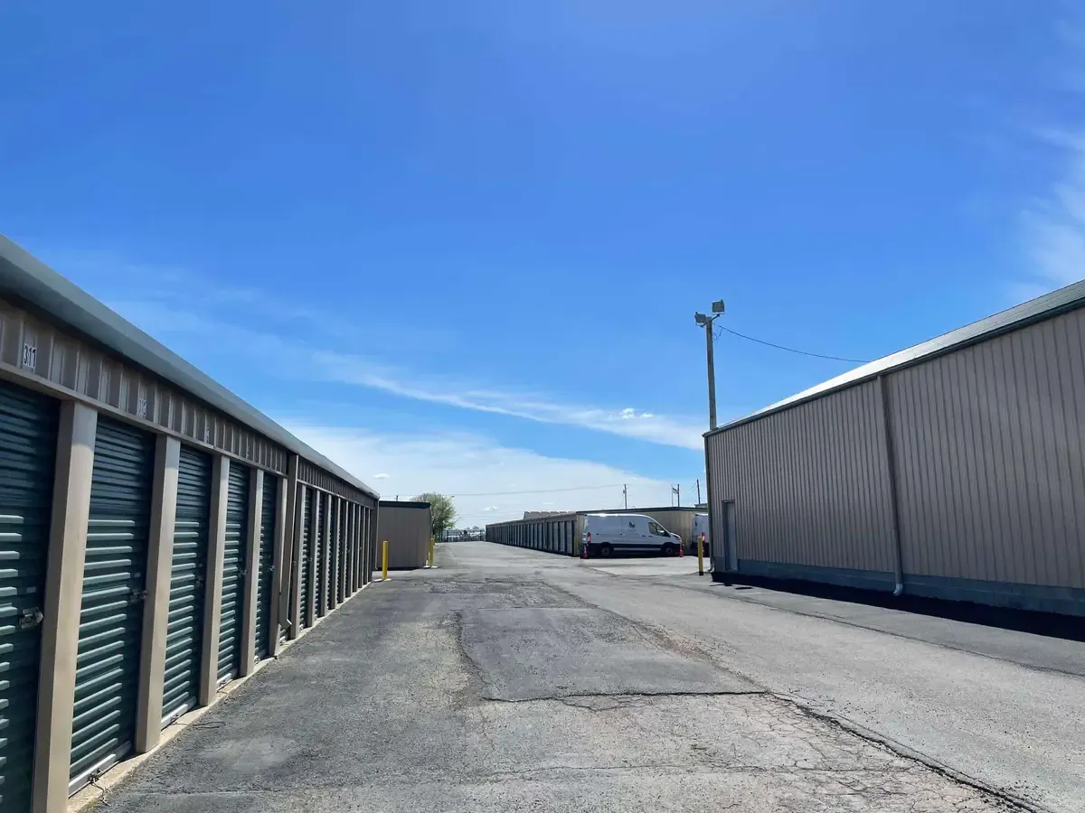 drive up storage units with green doors with truck in the back