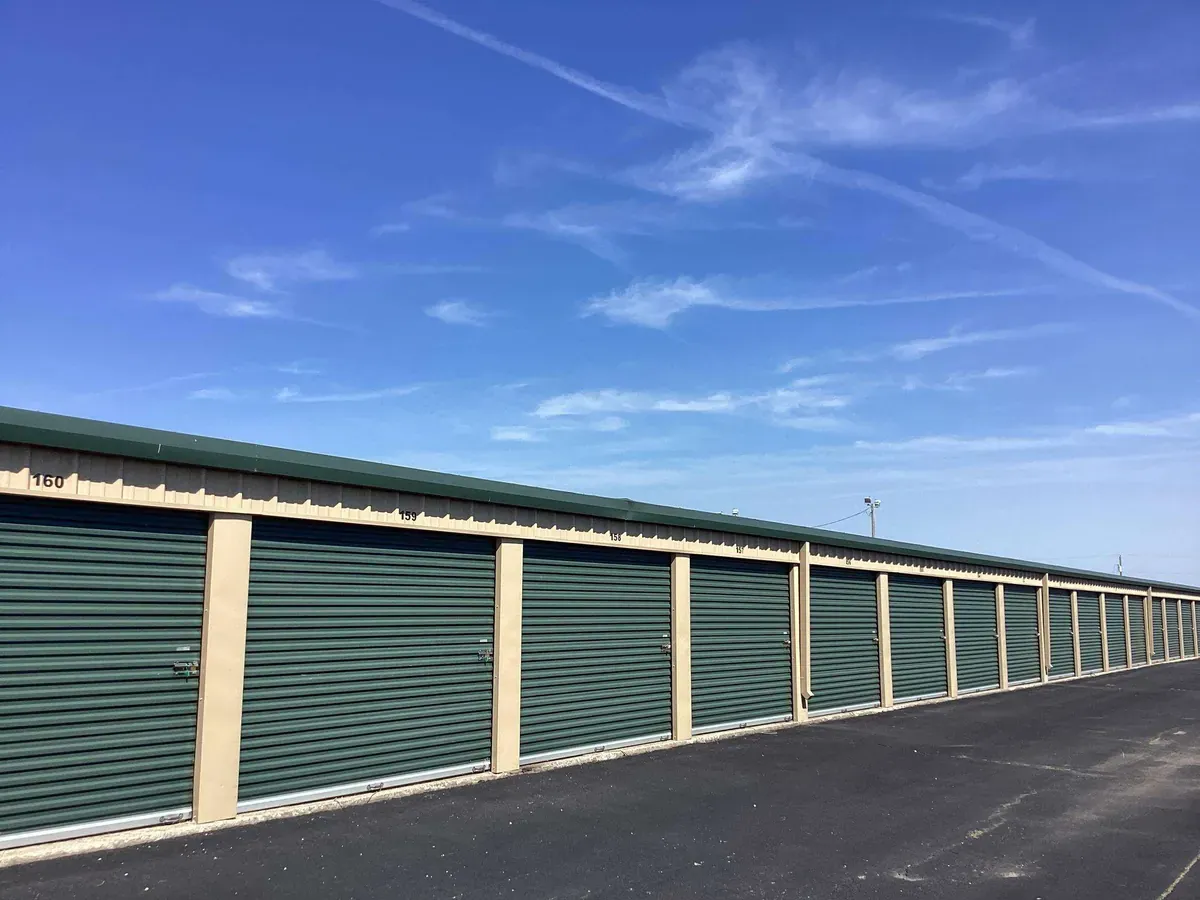 green doors on a row of drive up storage units