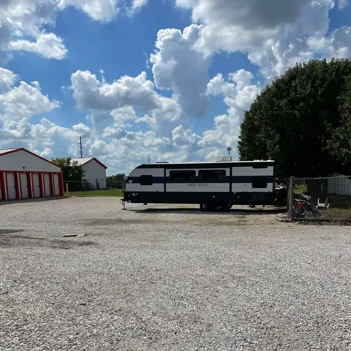 large camper parked on a gravel lot