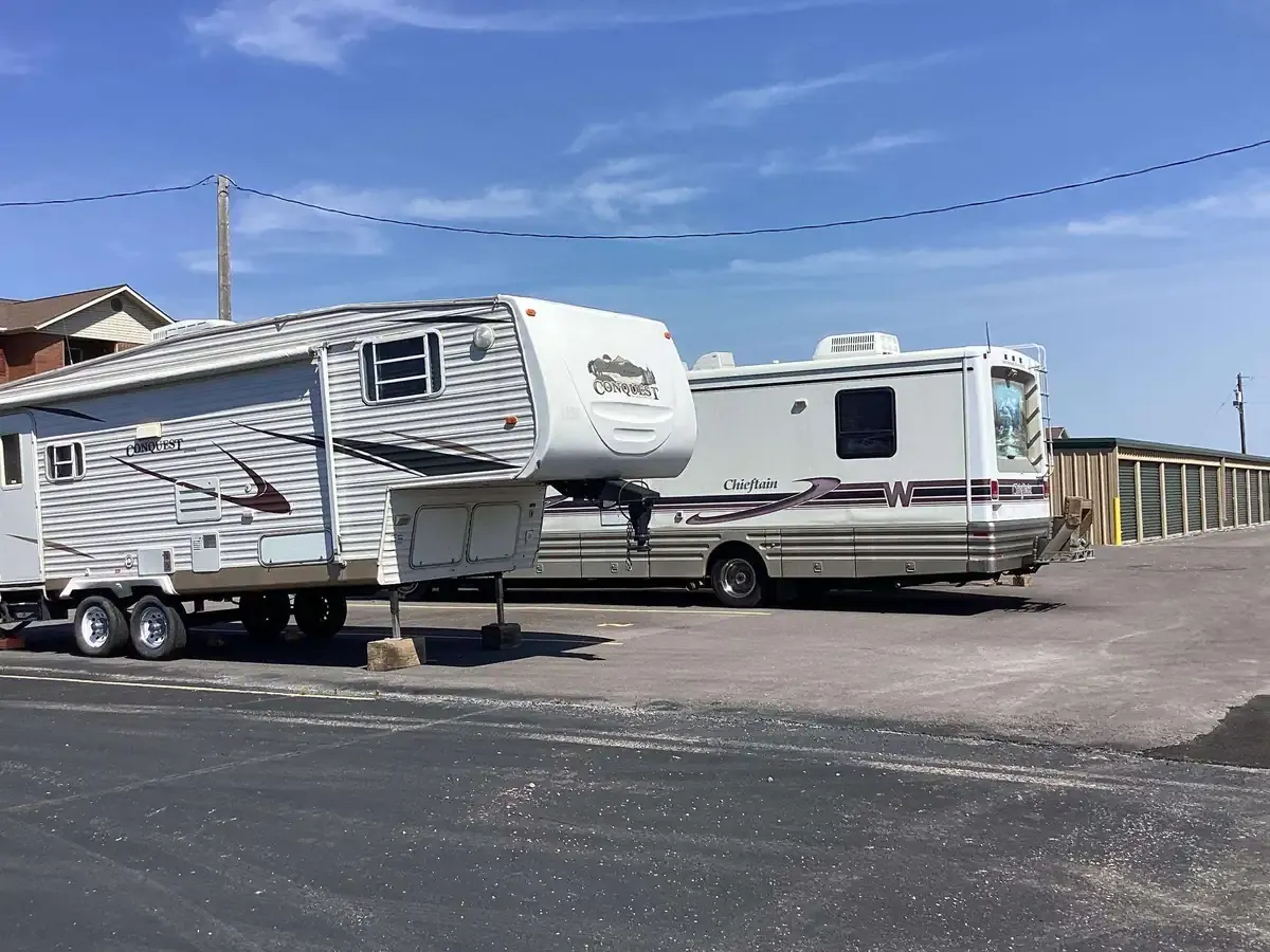 outdoor parking with rv and camper on a paved lot