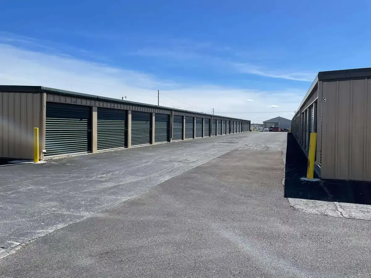 rows of drive up storage units with green doors
